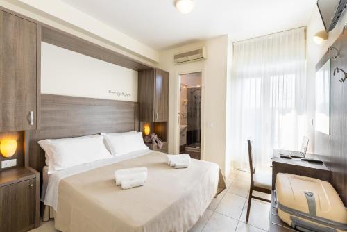 a bedroom with a bed and a desk and a television at Hotel Edelweiss Riccione in Riccione