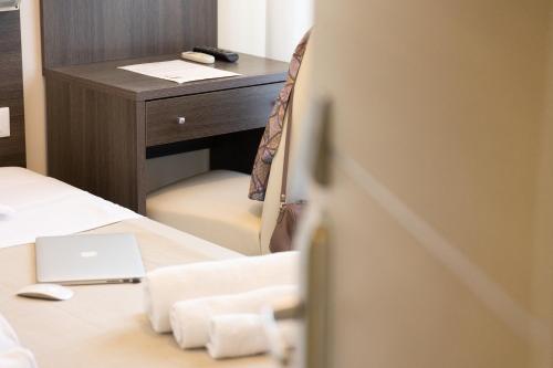 a bedroom with a desk and a bed with a laptop at Hotel Edelweiss Riccione in Riccione