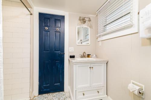 baño con puerta azul y lavamanos en Sandbars Inn - Beachside Cottage, en North Truro