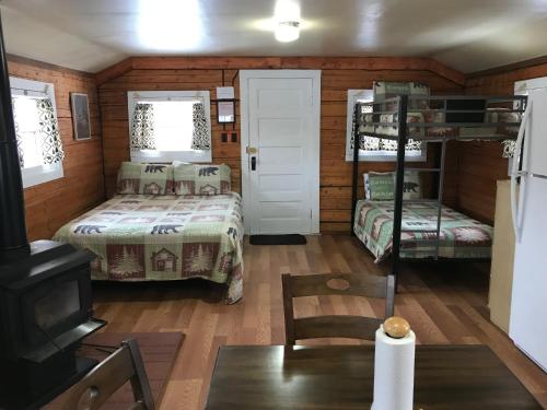 a bedroom with two bunk beds and a table at Grandview Cabins & RV Resort in South Fork