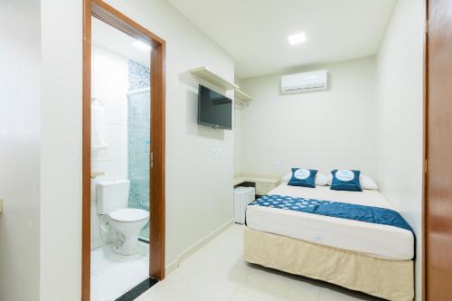 a small bedroom with a bed and a toilet at Pousada Meireles in Fortaleza