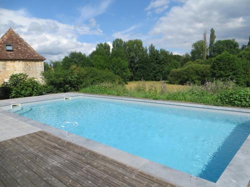 Lamonzie-Montastruc的住宿－La Salamandre，一座位于花园中的游泳池,花园内设有砖屋