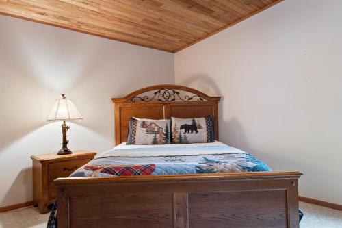 a bedroom with a wooden bed and a lamp at GolfView GetAway in Eagle River