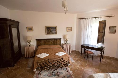 Schlafzimmer mit einem Bett, einem Tisch und einem Schreibtisch in der Unterkunft Azienda Agrituristica Seliano in Paestum