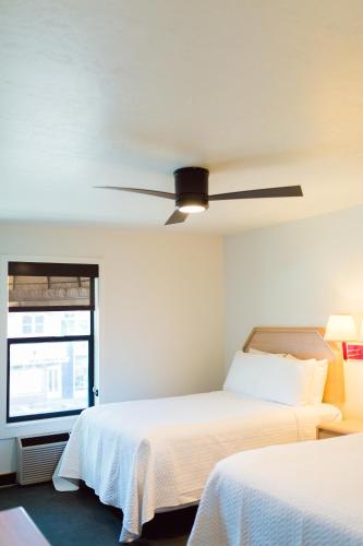 a bedroom with two beds and a ceiling fan at Two Sunsets Hotel in Panguitch