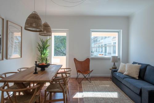 a living room with a blue couch and a table at Inesquecível estadia na praia de Carcavelos in Carcavelos