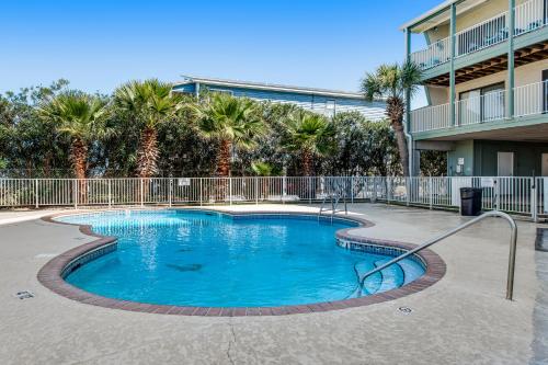 a swimming pool in a resort with palm trees at The Landing 203 by Meyer Vacation Rentals in Gulf Shores
