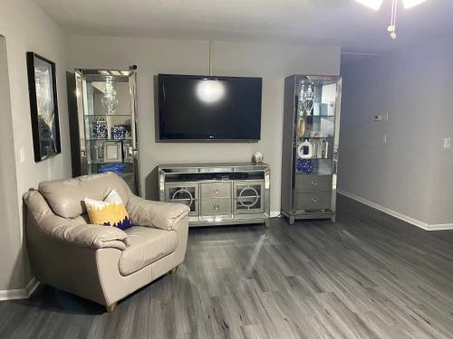 a living room with a couch and a flat screen tv at Sweet dreams private room across from the Hard Rock Casino in Tampa