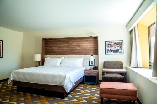 a hotel room with a bed and a chair at Holiday Inn Tlaxcala by IHG in Tlaxcala de Xicohténcatl