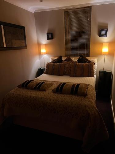 a bedroom with a large bed with two pillows at Gleneagles Lettings in Auchterarder