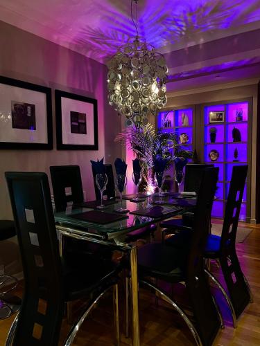 a dining room with a table with chairs and a chandelier at Gleneagles Lettings in Auchterarder