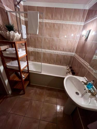 a bathroom with a sink and a bath tub at Gleneagles Lettings in Auchterarder