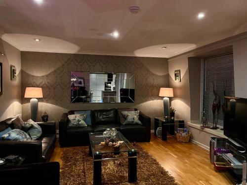 a living room with a couch and a mirror at Gleneagles Lettings in Auchterarder