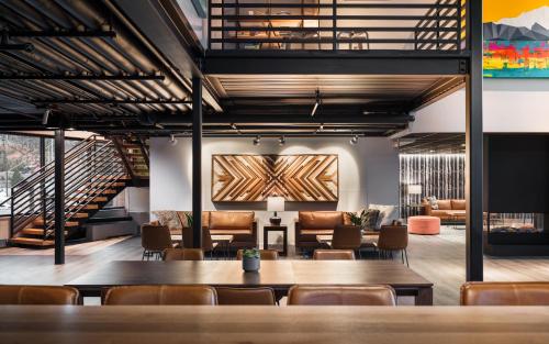 a dining room with tables and chairs and a staircase at The Block Hotel & Commons in Silverthorne