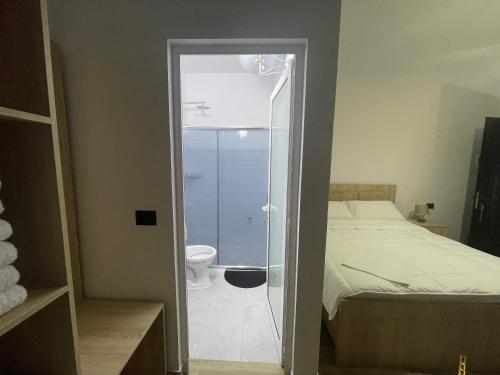 un baño con una puerta de cristal que conduce a un dormitorio en four generation hotel, en Široka