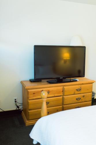 a television on top of a dresser in a bedroom at Two Sunsets Hotel in Panguitch