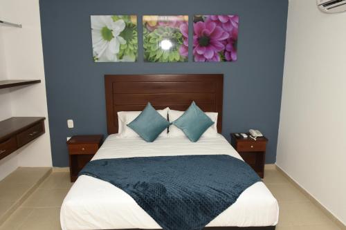 a bedroom with a large bed with blue walls at Hotel Kai Soledad Atlántico in Soledad