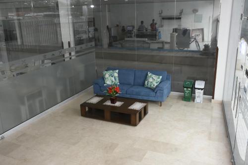 a living room with a blue couch and a coffee table at Hotel Kai Soledad Atlántico in Soledad