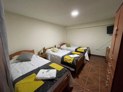 a room with two beds and a tv at Hostal CECIL + in Vallenar