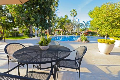 uma mesa preta e cadeiras ao lado de uma piscina em Hotel Del Rio em Navojoa