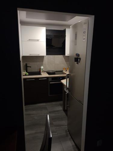 a kitchen with white cabinets and a refrigerator at Luxury apartaments Klimatyzacja 1 in Radom