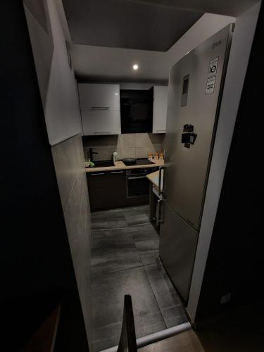 a small kitchen with a refrigerator and a sink at Luxury apartaments Klimatyzacja 1 in Radom
