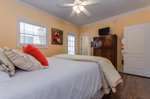 a bedroom with a white bed with pillows and a ceiling fan at Five O'clock Somewhere 4Bd By Pkrm in Pensacola