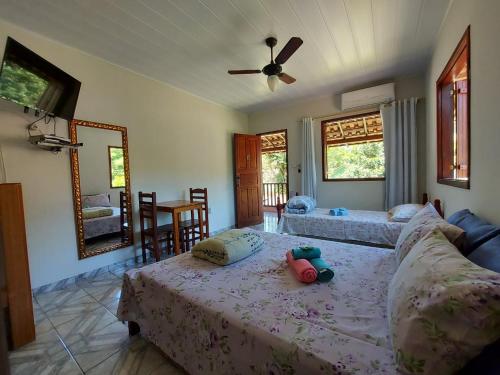 a bedroom with two beds and a ceiling fan at Pousada Flor da Manhã in Sana