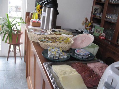 a counter with a bunch of cheese and other foods at Pension Šejko in Horní Planá