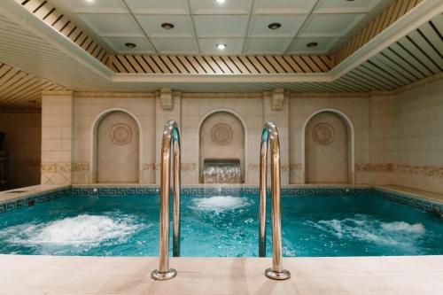 a large indoor pool with two water jets at Grand Hotel Emerald in Saint Petersburg