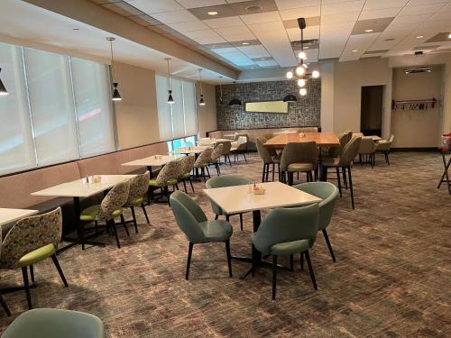 a restaurant with tables and chairs in a room at Holiday Inn Martinsburg by IHG in Martinsburg