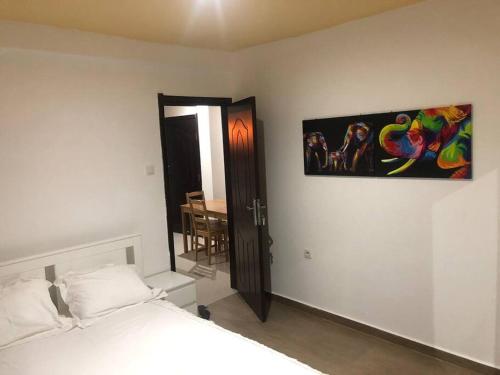 a bedroom with a bed and a painting on the wall at 28A, Lumir Apartamento #8, Luanda in Luanda