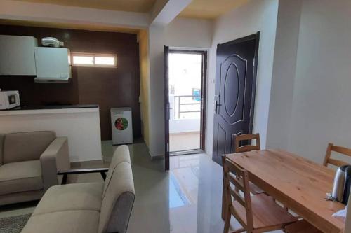 a living room with a couch and a table and a door at 28A, Lumir Apartamento #8, Luanda in Luanda