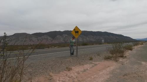 una persona de pie al costado de una carretera con un cartel en Lo de Jorge en Payogasta