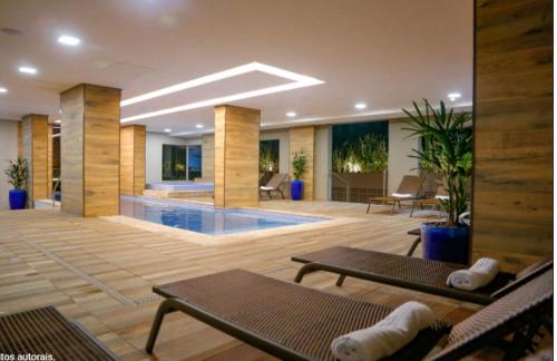 a lobby with a pool and tables and chairs at Enjoy Olímpia Park Resort in Olímpia