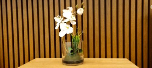 a vase with white flowers in it on a table at Beograd na vodi - BW AURORA LUXURY in Belgrade
