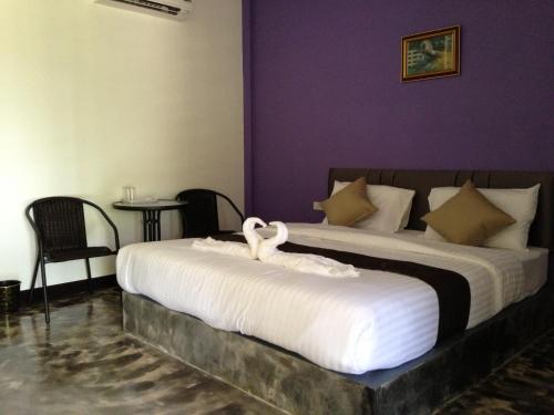 two beds in a room with two swans on them at Baan Rai Phufah Resort Chiangrai in Ban Pa Ruak