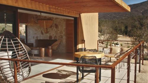 een patio met een tafel en stoelen en een open haard bij Mexico en la Piel in Valle de Guadalupe