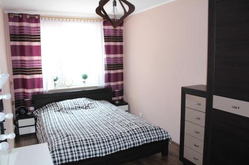 a small bedroom with a bed and a window at Luxury apartaments Klimatyzacja 2 in Radom