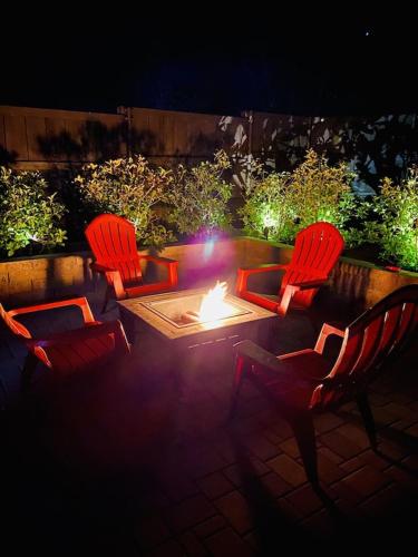 three chairs and a fire pit in a backyard at night at Beautiful Sedona Home Near Chapel of the Holy Cross in Sedona