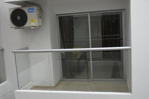 a glass door in a room with a fan at Hotel Kai Soledad Atlántico in Soledad