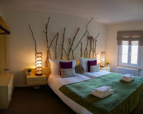 a bedroom with a large bed with two towels on it at Auberge de Duillier in Duillier