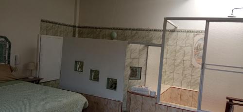 ein Schlafzimmer mit einer Dusche, einem Bett und einem Spiegel in der Unterkunft Motel Sahara Suites in Barranca