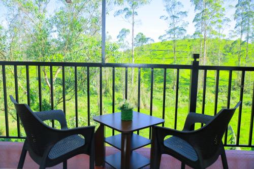 a table and chairs on a balcony with a view at Hill Cool Hotel & Restaurant in Hatton