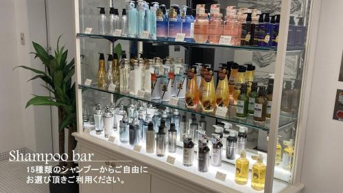 a display case filled with lots of bottles of alcohol at Amistad Hotel Fukuoka in Fukuoka