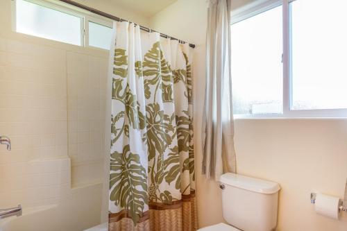 a bathroom with a toilet and a shower curtain at Pukeawe Hale in Volcano