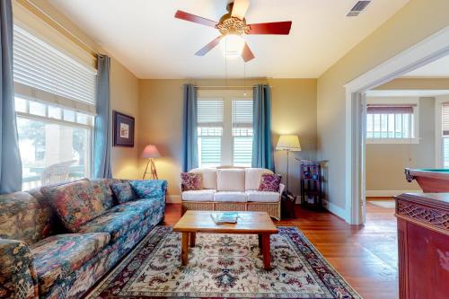 uma sala de estar com um sofá e uma mesa em Greener Grasses em Galveston