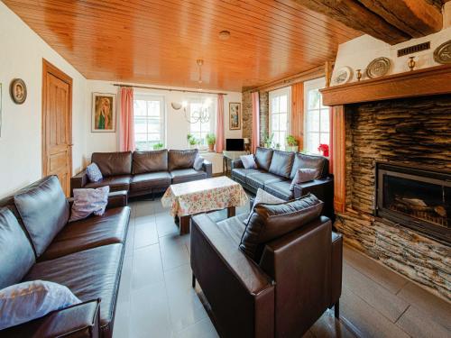 a living room with leather furniture and a fireplace at Cozy farmhouse in Brisy with sauna 