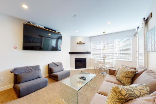 a living room with a couch and chairs and a tv at Market Place Lodge 249 in Whistler