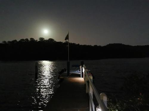 a dock on a lake at night with the moon at Your Perfect Waterfront Escape in Bar Point